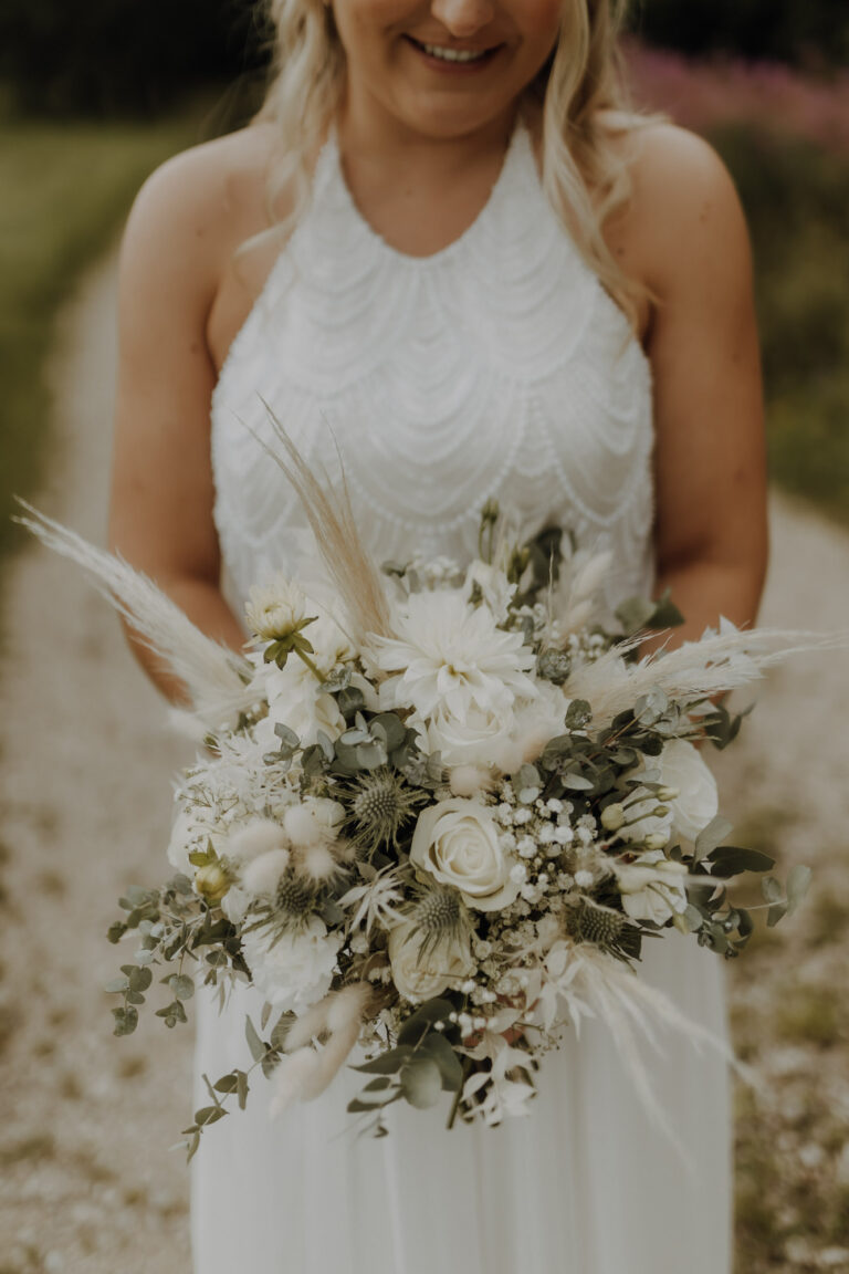 Detailfoto von Brautstrauß und Brautkleid beim Brautpaarshooting