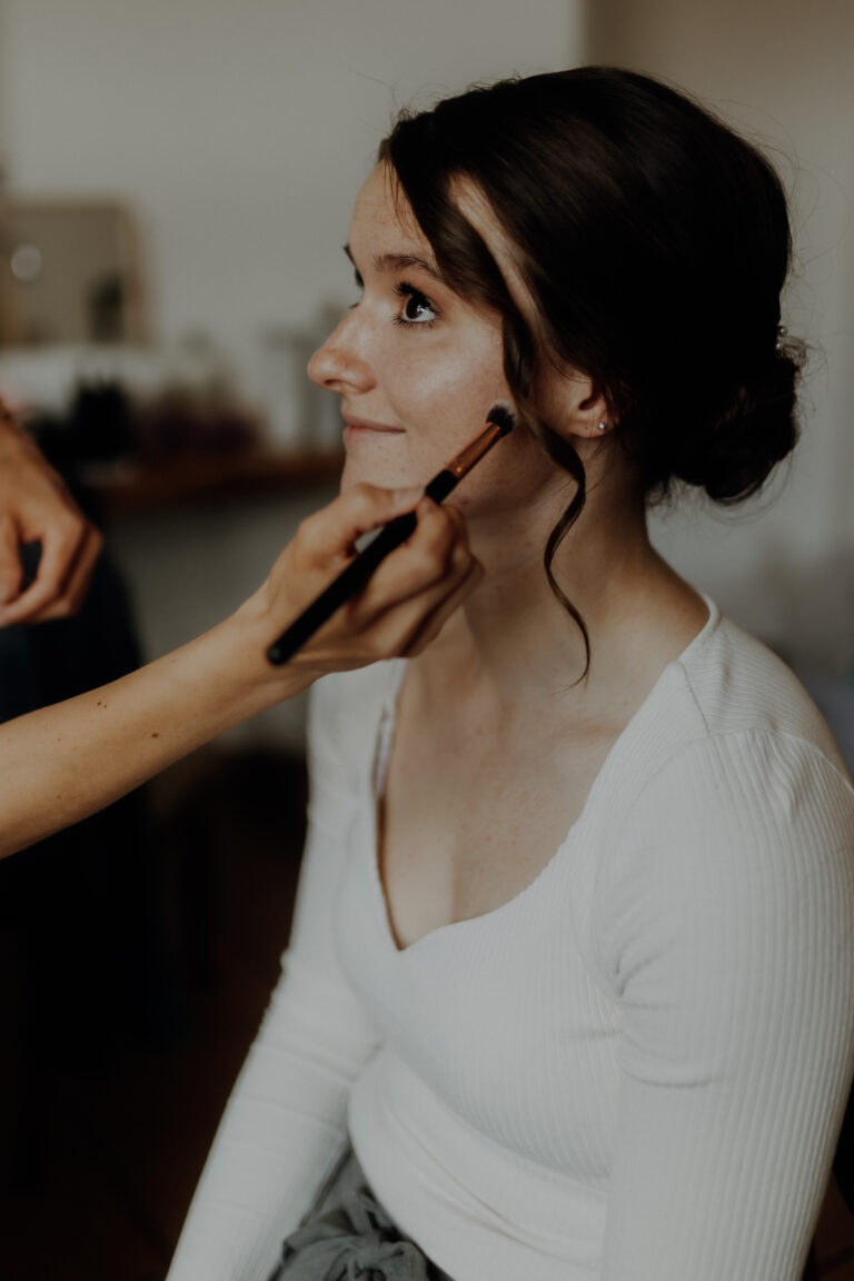 Braut wird beim Getting Ready an ihrem Hochzeitstag geschminkt