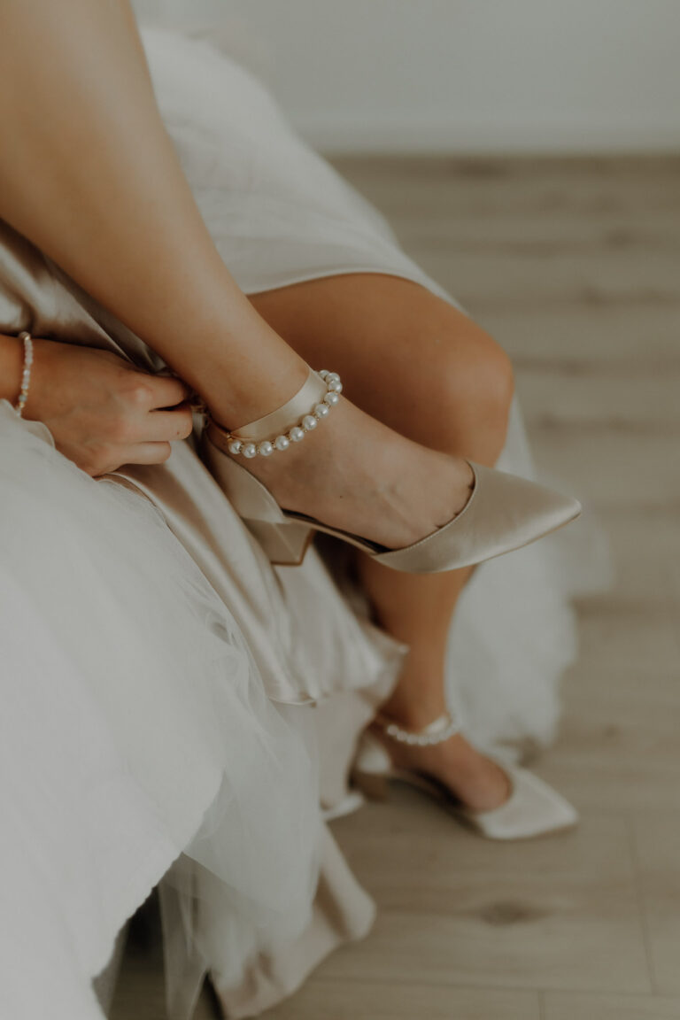 Detailaufnahme wie die Braut beim Getting Ready in Stuttgart ihre Brautschuhe mit Perlen versetzt anzieht